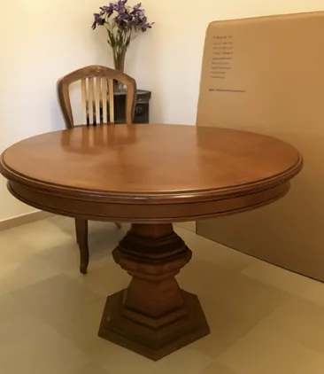 Mesa redonda de comedor en madera oscura antes del lacado