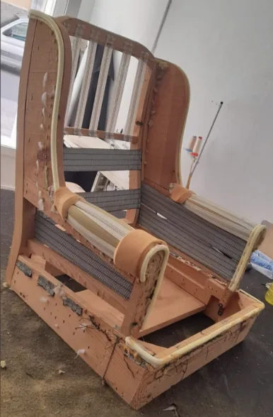 Estructura del sillón orejero desmontada en el taller con muelles a la vista
